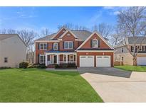 Charming two-story brick home boasts a lush front lawn and a convenient two-car garage at 3967 Bellingrath Main Nw, Kennesaw, GA 30144