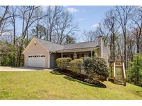 Charming ranch-style home featuring manicured lawn, attached garage, and a quaint front porch with inviting curb appeal at 263 Keller Dr, Mcdonough, GA 30252