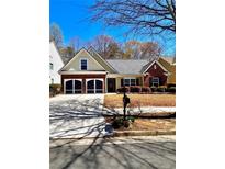 Charming home with brick and siding, a two-car garage, and manicured bushes at 779 Harvest Brook Dr, Lawrenceville, GA 30043