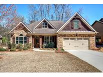 Charming stone and siding home featuring a well-manicured lawn and a two-car garage at 115 Dorys Way, Dallas, GA 30157