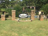 Inviting Robinwood Condominiums entrance featuring brick pillars, manicured lawn, and colorful flower beds, offering a warm welcome at 2340 Beaver Ruin Rd # 89, Norcross, GA 30071