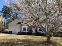 Charming two-story home with brick accents, a two-car garage, and a beautiful flowering tree in the front yard at 645 Legend Sw Ct, Atlanta, GA 30331