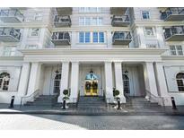 Grand building entrance with columns and stairs leading to the gold-trimmed doors at 195 14Th Ne St # 1908, Atlanta, GA 30309