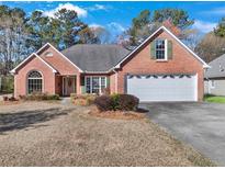 Charming single-story brick home with a well-manicured lawn and attached two car garage at 1050 Sunny Field Ct, Lawrenceville, GA 30043