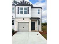 Charming two-story home features a brick and siding exterior, attached garage, and manicured landscaping at 5897 Mattan Trl # 67, Lithonia, GA 30058