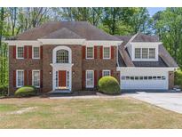 Charming two-story brick home featuring red shutters and a well-manicured lawn at 3590 Lester Sw Ct, Lilburn, GA 30047