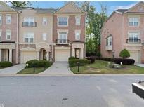 Beautiful brick townhome featuring a well-manicured lawn and attached garages at 1186 Arbor Park Sw Ln, Atlanta, GA 30311