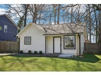 Charming single-story home featuring white siding, black trim, a well-maintained lawn and mature trees at 5722 Woodvalley Trce, Norcross, GA 30071