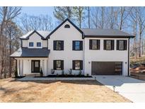 Beautiful two-story home boasts black trim, neutral paint, attached garage, and professional landscaping at 1205 Cottonwood Se Grv, Conyers, GA 30094