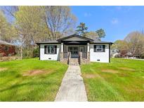 Charming single-story home with white siding, black trim, and a well-manicured front yard at 936 South Ave, Forest Park, GA 30297