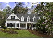 Beautiful two-story traditional home with a covered front porch, black shutters and a well-manicured front yard at 12680 Old Surrey Pl, Roswell, GA 30075