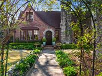Charming brick Tudor-style home with a stone chimney and beautifully landscaped front yard, creating a welcoming curb appeal at 1620 N Pelham Ne Rd, Atlanta, GA 30324