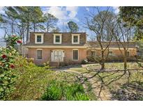 Charming two-story brick home featuring a well-manicured lawn and mature trees at 2373 Woodcreek Ct, Tucker, GA 30084