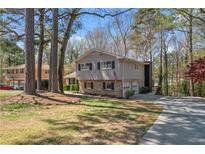 Charming two-story home with a brick-and-siding exterior and a two-car garage nestled among mature trees at 3937 Locklear Way, Atlanta, GA 30360