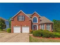 Charming two-story brick home with a manicured lawn and a two-car garage at 1030 Blankets Creek Dr, Canton, GA 30114