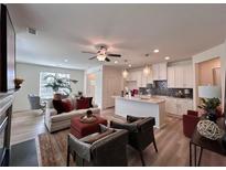 Open-concept living area featuring modern furnishings, a ceiling fan, and a view into the gourmet kitchen at 1800 Emory Ln # 98, Conyers, GA 30013
