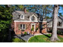 Charming brick home featuring a manicured lawn, dormer windows, and mature trees at 1691 N Pelham Ne Rd, Atlanta, GA 30324