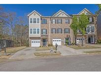 Charming brick townhome with a one-car garage and well-maintained front lawn at 2138 Mill Garden Run, Buford, GA 30519