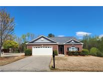 Charming single-story brick home with a well-manicured front yard and attached two car garage at 1705 Rolling View Dr, Cumming, GA 30040