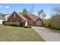 Charming red brick home features a manicured lawn, mature landscaping, and traditional architectural details at 625 Sycamore Glen Nw Ct, Lawrenceville, GA 30044