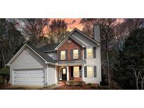 Two-story home showcasing charming brick accents, a well-manicured lawn, and a two-car garage at 802 Eagle Glen Xing, Woodstock, GA 30189