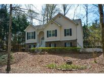 Charming two-story home featuring a brick-and-siding exterior with dark shutters and a landscaped front yard at 2690 Wanda Woods Rd, Cumming, GA 30041