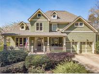 Charming two-story home features a welcoming front porch, two-car garage and a beautiful landscaped yard at 3828 Morning Meadow Ln, Buford, GA 30519