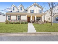 Charming two-story home with a welcoming front porch, well-maintained lawn, and stone accents at 5034 Little Harbor Way, Acworth, GA 30101