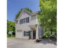 Charming two-story home featuring gray siding, black shutters, and a convenient attached garage at 1433 Carroll Drive Nw, Unit #3, Atlanta, GA 30318