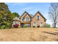 Charming brick home with a manicured lawn and mature trees offers classic curb appeal at 5136 Heron Bay Blvd, Locust Grove, GA 30248