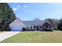 Charming single Gathering home featuring a large front yard, attached garage, and beautiful landscaping at 895 Burton Ridge Dr, Loganville, GA 30052