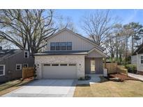 Charming two-story home with a brick and siding exterior, landscaped yard and large driveway at 1604 Temple Ave, Atlanta, GA 30337