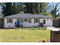 Charming home with a well-manicured lawn and a bright blue front door, creating a welcoming curb appeal at 1882 Rosewood Rd, Decatur, GA 30032