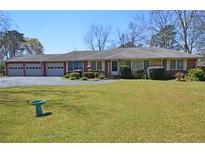 Charming single-story home with a brick facade, well-maintained lawn, and a spacious four-car garage at 3528 Highway 42 S, Locust Grove, GA 30248