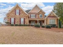 Inviting two-story home with a combination stone and siding exterior and manicured landscaping at 103 Gold Springs Ct, Canton, GA 30114