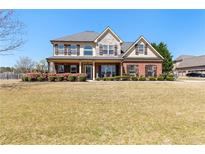 Charming two-story brick home with a well-maintained front yard and inviting covered porch at 2100 Spruce Lake Dr, Dacula, GA 30019