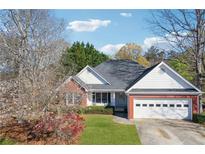 Charming single-story home with brick accents, lush lawn, and attached two-car garage at 115 Dearing Woods Way, Covington, GA 30014