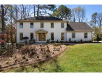 Beautifully renovated two-story brick home with a manicured lawn and mature trees at 2363 Welton Pl, Atlanta, GA 30338