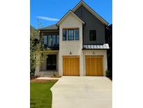 Charming two-story home featuring a mix of brick and siding, complemented by wooden garage doors at 2583 Apple Valley Rd, Brookhaven, GA 30319