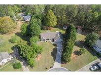 Expansive aerial view of a charming ranch home with a long drive and lush green trees at 313 Ridge Hill Cir, Canton, GA 30115