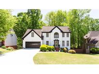 Charming two-story home with a well-manicured lawn and lush green trees at 3612 Tree View Dr, Snellville, GA 30078
