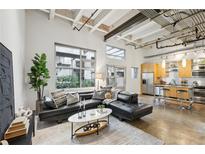 Bright living room features industrial ceiling, large windows, and contemporary decor at 1661 La France Ne St # 102, Atlanta, GA 30307