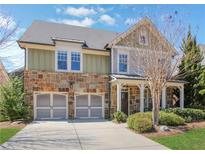 Charming two-story home featuring a stone facade, a two-car garage, and a cozy front porch at 3492 Brookleigh Ne Ln, Atlanta, GA 30319