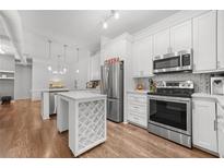 Modern kitchen features stainless steel appliances, white cabinetry, and a wine rack island at 5300 Peachtree Rd # 1212, Atlanta, GA 30341