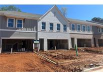 New townhomes feature gray and white brick exteriors, garage spaces and lawn preparation in progress at 105 Priestwood Ln, Acworth, GA 30102