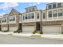Charming townhomes with brick and neutral toned siding, garages, and beautifully trimmed black windows at 2068 Wheaton Way, Atlanta, GA 30328