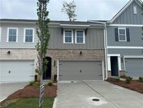 Charming townhome featuring a two-car garage, brick accents, and neutral color palette at 113 Priestwood Ln, Acworth, GA 30102
