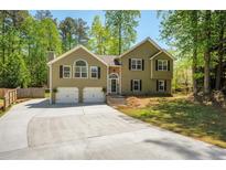 Charming home featuring a two-car garage, beautiful landscaping, and a well-maintained front yard at 404 Queensbury Pl, Acworth, GA 30102