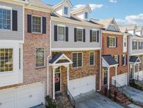 Charming townhome showcasing a well-maintained facade, stone accents, and attached garage at 1236 Brickton Nw Dr, Atlanta, GA 30318