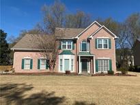 Charming two-story brick home with green shutters and a well-manicured front yard at 1603 Pinder Point Dr, Lawrenceville, GA 30043